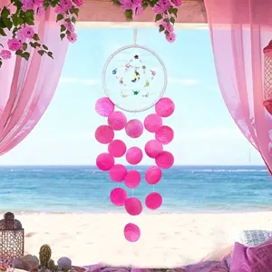 Handmade pink capiz shell wind chime dream catcher with star moon charms beach background
