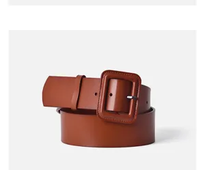 Detailed view of the wide caramel brown leather belt with square buckle for coats.