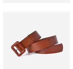 Detailed shot of women wide brown leather trench coat belt with chunky square buckle.