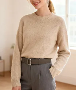 Detail view of a retro matte leather belt with a metal pin buckle, styled on grey pants.