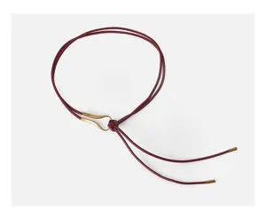 Detail of burgundy PU leather rope belt with gold metal slider, elegant waist accessory.