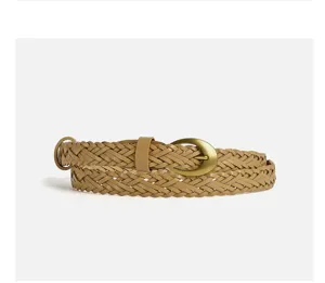 Dettaglio ravvicinato di un'elegante cintura treccia da donna in khaki con fibbia vintage retro.