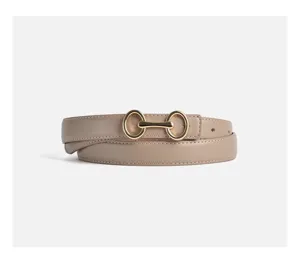 Vista dettagliata della cintura in pelle beige minimalista da donna con fibbia dorata.