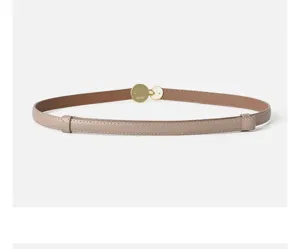 Detailed view of women thin leather belt with gold round buckle casual fashion versatile accessory.