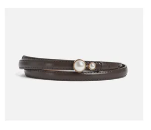 Detail shot of thin brown leather belt featuring elegant dual pearl decorative metal buckle.
