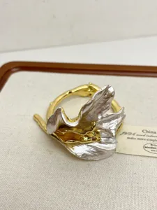 Exquisite metallic sculptural flower bangle detail, artistic gold and silver tone open bracelet.