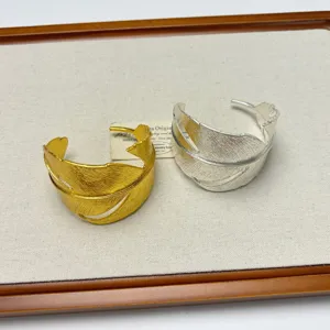 Exquisite metal leaf cuff bracelet in gold and silver, trendy open design fashion accessory.