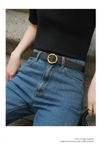 Minimalistische echt lederen riem met getextureerde gouden ronde gesp voor dagelijkse looks.