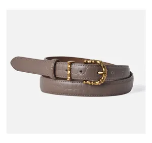 Detailed view of women's crocodile pattern leather belt with a chic golden metal buckle.