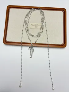 Detailed close-up view of the multi-layered pearl necklace featuring a chic bow pendant.