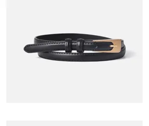Dettaglio cintura sottile nera in pelle da donna, elegante fibbia dorata per outfit quotidiani.
