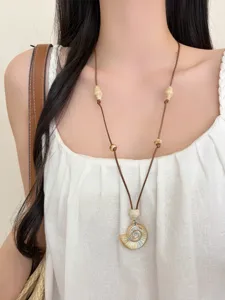 Bohemian seashell pendant necklace with brown cord, perfect for beach vacation styles.