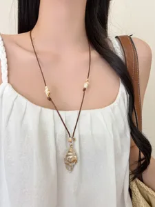Boho seashell pendant necklace detail shot, adjustable brown cord choker accessory.