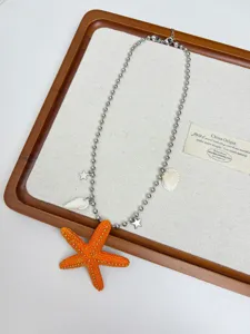 Detailed view of bohemian starfish pendant necklace with shell charms on display tray.