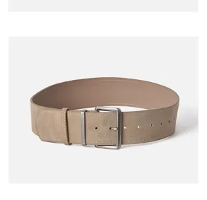 Close-up of wide khaki suede leather belt with metallic pin buckle and double loop.