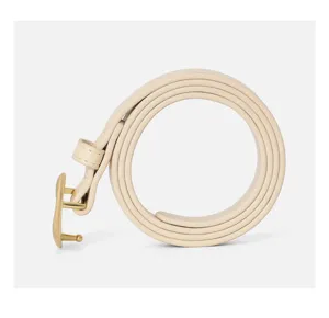 Detailed view of beige leather belt with gold heart buckle, elegant women accessory close up.