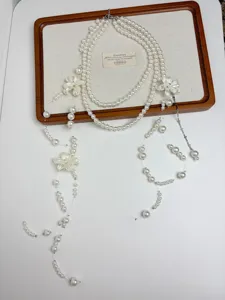 Detail shot of layered pearl necklace showcasing delicate flower pendants and bead charms.