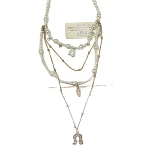 Detail shot of multi-layer pearl and metal chain necklace with vintage horseshoe pendant.