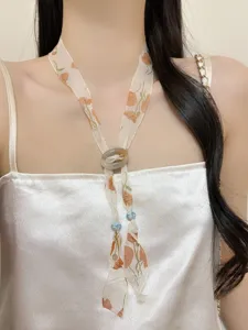 Close-up view of the vintage floral silk scarf necklace featuring delicate beads and ring.