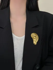 Gros plan d'une broche d'oreille en métal doré unique, détail idéal pour un style chic.