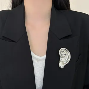 Broche d'oreille métallique surréaliste pour femme, épingle de costume argentée unique.