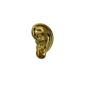 Broche oreille surrealiste doree en metal aux formes irregulieres accessoire de mode pour femme