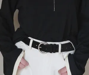 Matte pin buckle belt detail shot, black leather strap with silver metal buckle, versatile design.
