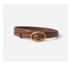 Brown leather belt for women with sleek oval buckle, minimal style detail accessory.