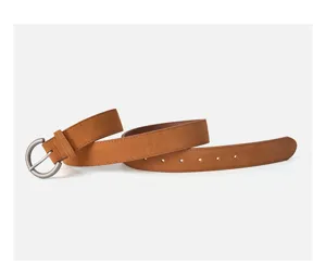 Close-up of brown suede women belt with vintage round metal buckle, stylish accessory.
