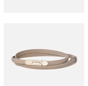Detailed view of the thin leather women's belt featuring a sleek metallic clasp closure.
