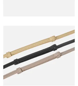 Close-up detail of thin women leather belts with fine stitching and chic metal loops.