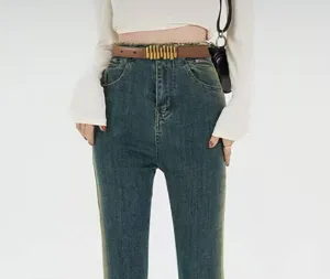 Detail shot of a trendy leather belt with metallic bar buckle worn with stylish jeans.