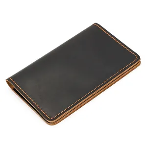 Black genuine leather card holder detail, vintage bi-fold wallet with orange stitch close-up