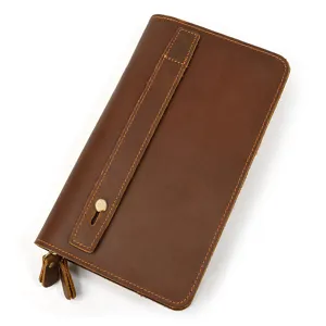 Close-up detail of the brown leather vintage wallet showing fine stitching and metal snap strap.