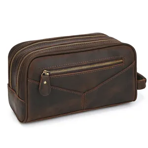 Vintage brown leather toiletry bag detail showing premium texture, dual zippers and front pocket.