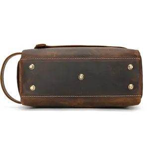 Detailed view of genuine crazy horse leather toiletry bag bottom with metal feet studs.