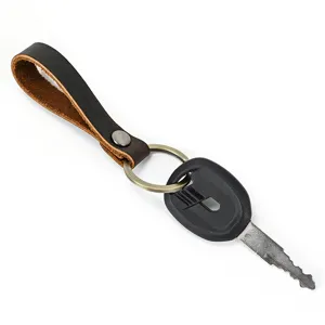 Gedetailleerd overzicht van de vintage lederen sleutelhanger met metalen ring en zwarte sleutel.