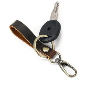 Close-up detail van vintage crazy horse lederen sleutelhanger met bronzen hardware ring.