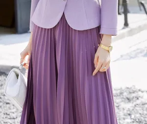 Detailed close-up shot of elegant purple pleated long skirt and tailored suit jacket outfit.