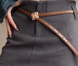 Detailed close-up shot of the brown thin leather belt with an elegant rose metal buckle.