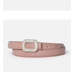 Detailansicht eines eleganten rosa Ledergürtels für Damen mit funkelnder Strassschnalle.