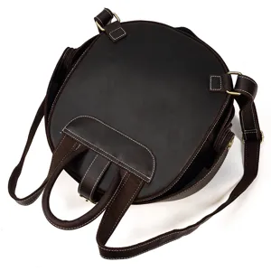 Detailed view of the round crazy horse leather backpack, showing durable stitching and straps.