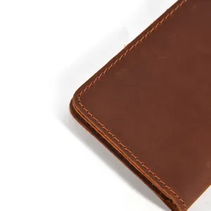 Close-up detail of vintage cowhide cardholder showing fine stitching and leather texture.
