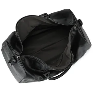 Détail intérieur du sac de voyage en cuir noir montrant sa grande capacité et ses fermetures.
