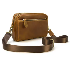 Vue détaillée du sac bandoulière en cuir véritable pour homme marron avec sangle large et élégante.