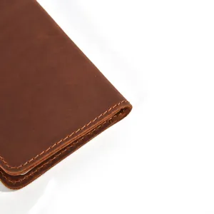 Close-up detail of vintage brown cowhide leather card holder showing fine stitching.