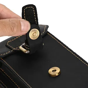Black leather waist bag detail shot showing brass magnetic snap and durable stitching