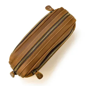 Vue de détail en gros plan d'une pochette multi-fermeture éclair en cuir marron vintage.