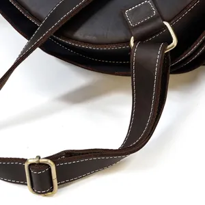 Detailed shot of dark brown crazy horse leather backpack strap with metal buckle and stitching.