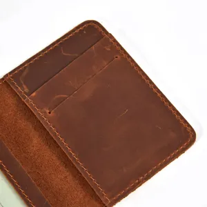 Detail view of a handmade brown leather card holder with multiple slots and vintage texture.